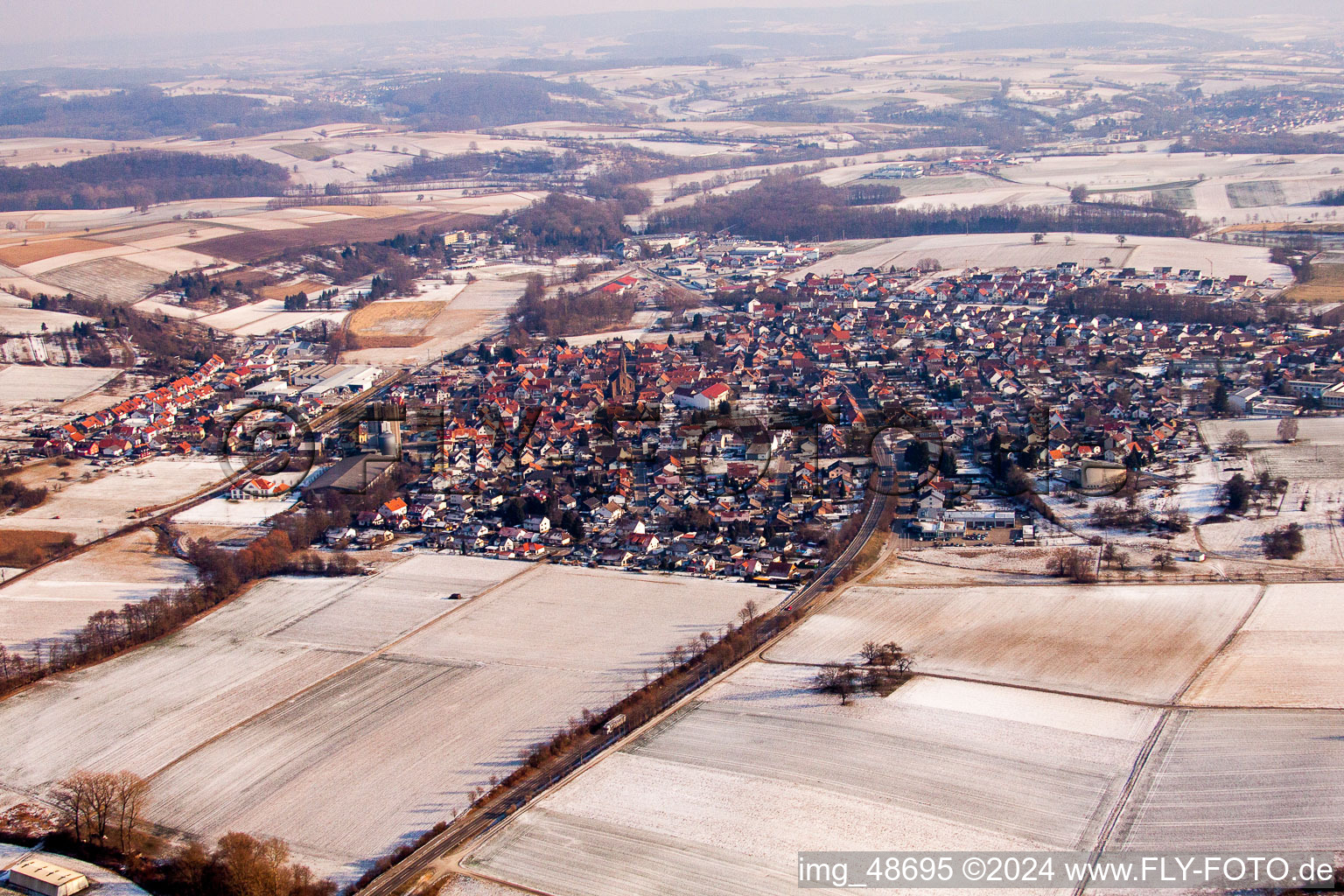 Wintry snowy Village - view on the edge of agricultural fields and farmland in the district Muenzesheim in Kraichtal in the state Baden-Wurttemberg, Germany