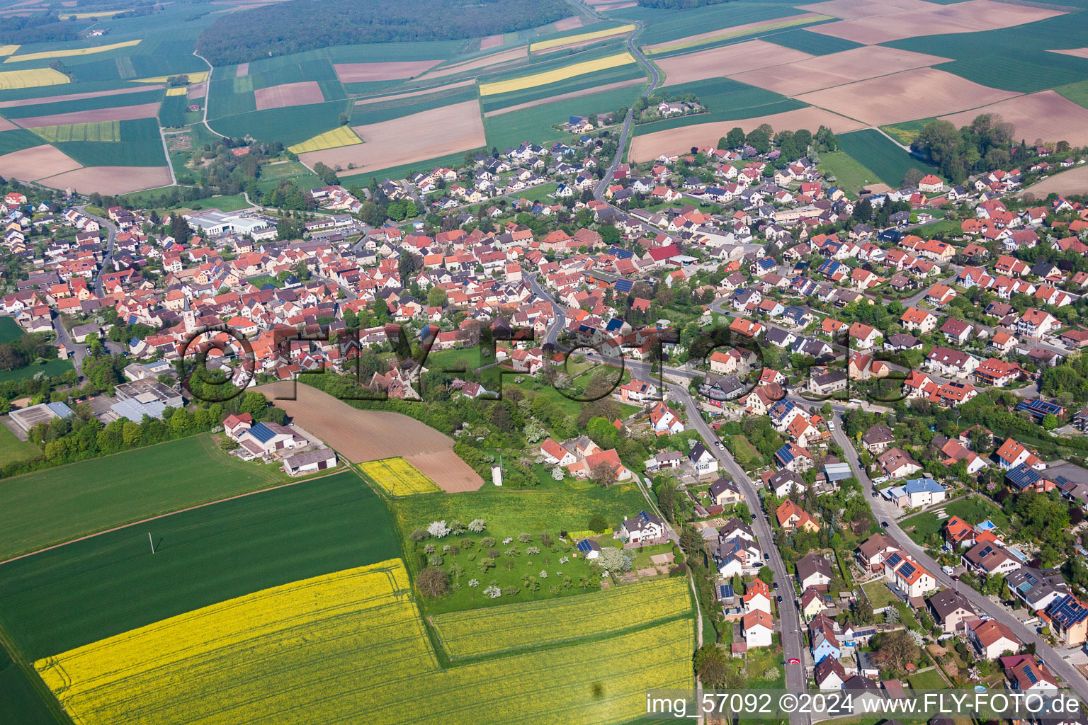 Aerial view of Village - view on the edge of agricultural fields and farmland in Schwanfeld in the state Bavaria, Germany