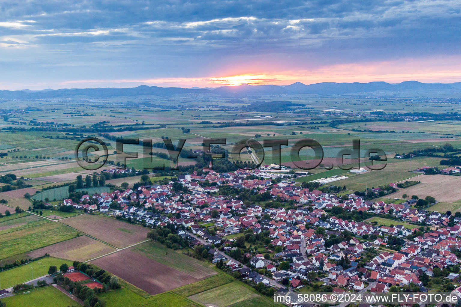 Village - view at sunset on the edge of agricultural fields and farmland in Minfeld in the state Rhineland-Palatinate, Germany