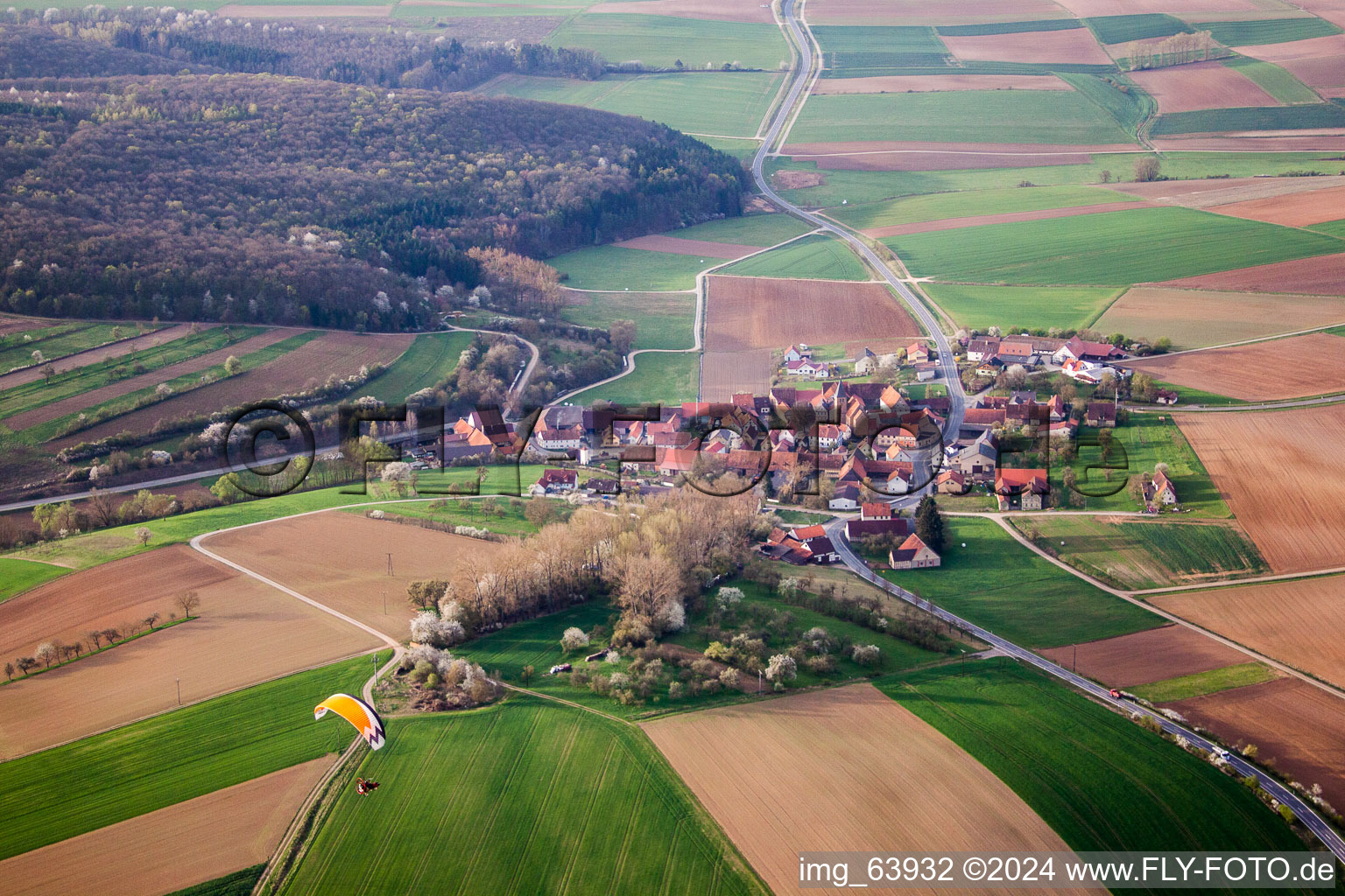 Aerial view of Village - view on the edge of agricultural fields and farmland in Junkershausen in the state Bavaria, Germany