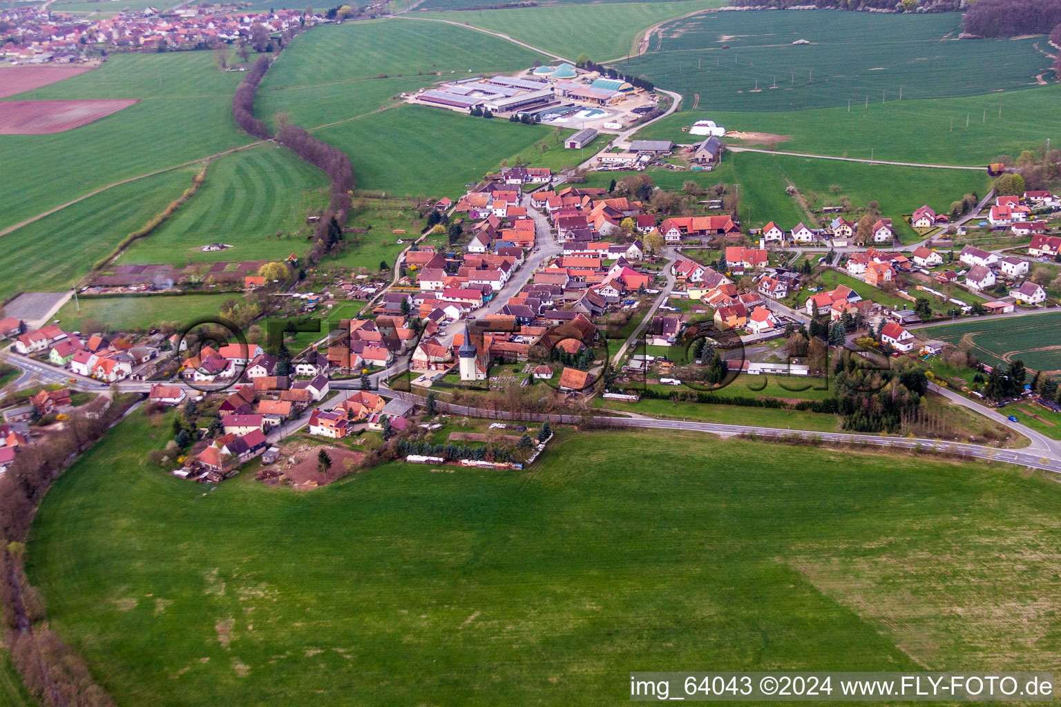 Aerial view of Village - view on the edge of agricultural fields and farmland in Simmershausen in the state Thuringia, Germany