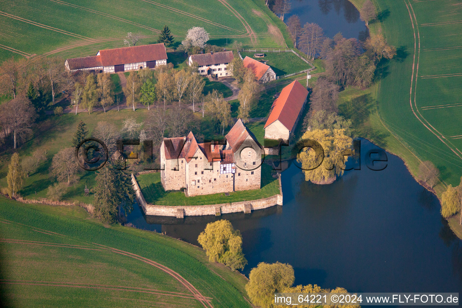 Farm and water mill on the edge of cultivated fields and milling lake in the district Schwanhausen in Sulzdorf an der Lederhecke in the state Bavaria