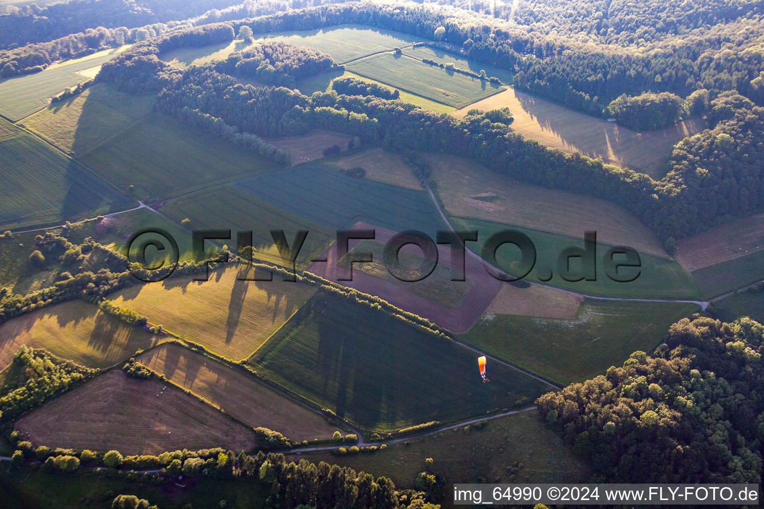 Paragliding over fields and forests in Pegestorf in the state Lower Saxony, Germany