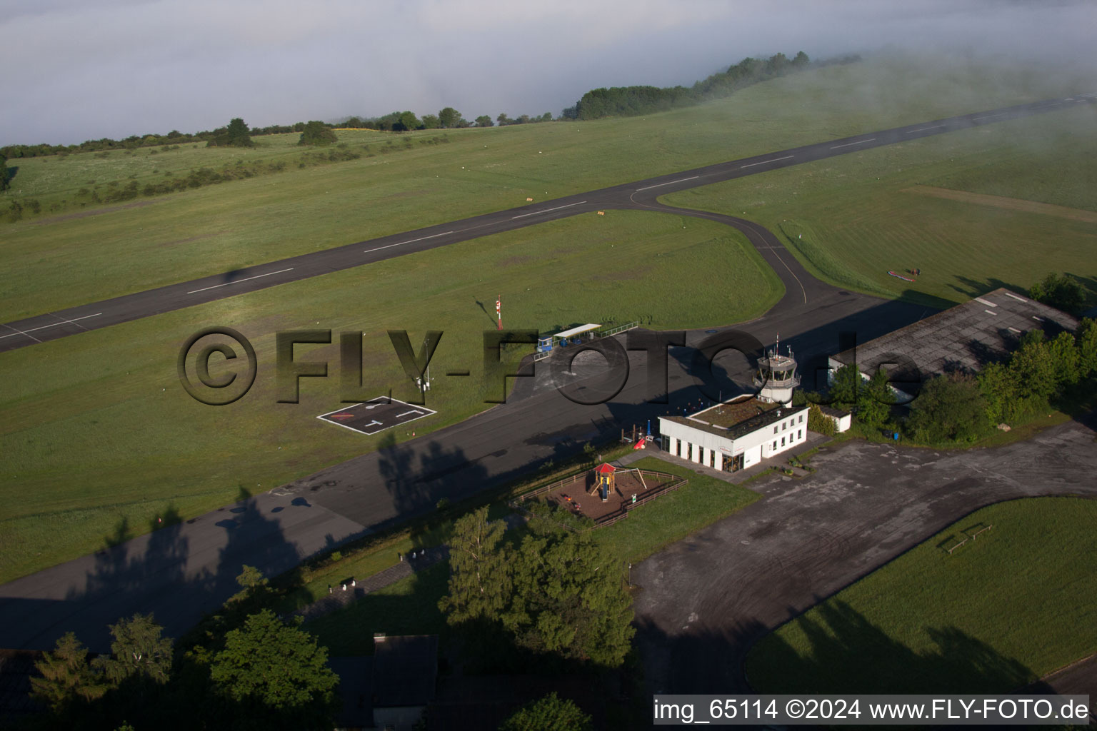 Runway with tarmac terrain of airfield Hoexter-Holzminden with morning mist in the district Brenkhausen in Hoexter in the state North Rhine-Westphalia, Germany