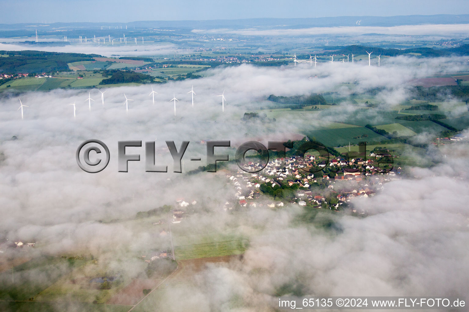 Wind turbine windmills in morning mist on a field in the district Fuerstenau in Hoexter in the state North Rhine-Westphalia