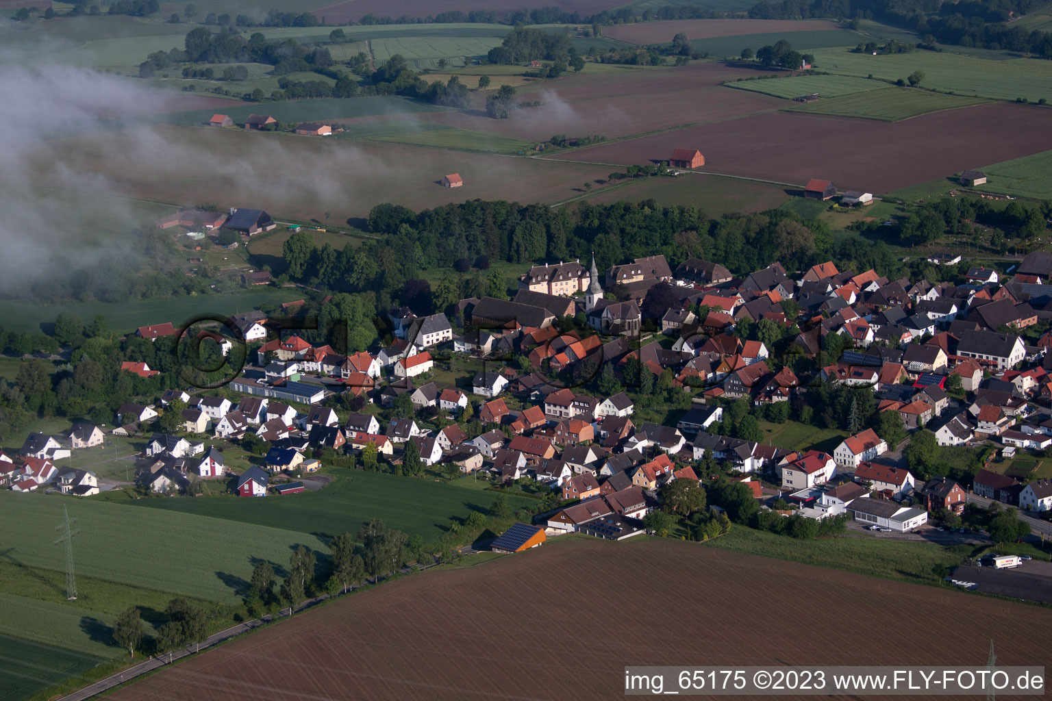 Aerial view of Village - view on the edge of agricultural fields and farmland in Marienmuenster in the state North Rhine-Westphalia, Germany
