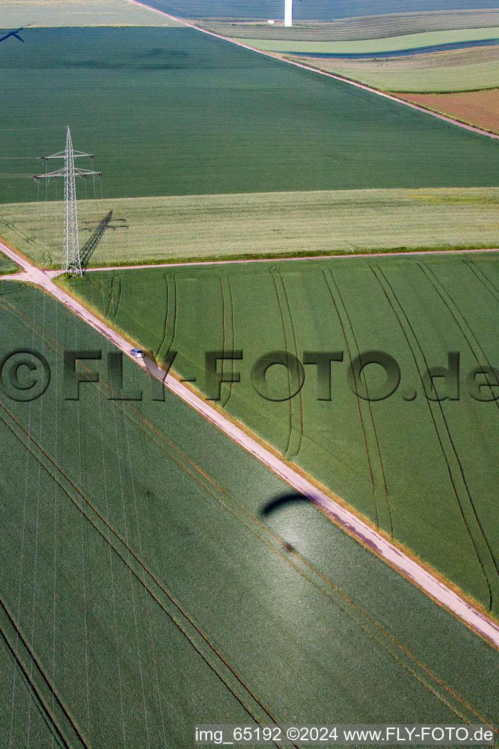 Shadow of paraglider next to high voltage pylon in the district Bredenborn in Marienmünster in the state North Rhine-Westphalia, Germany