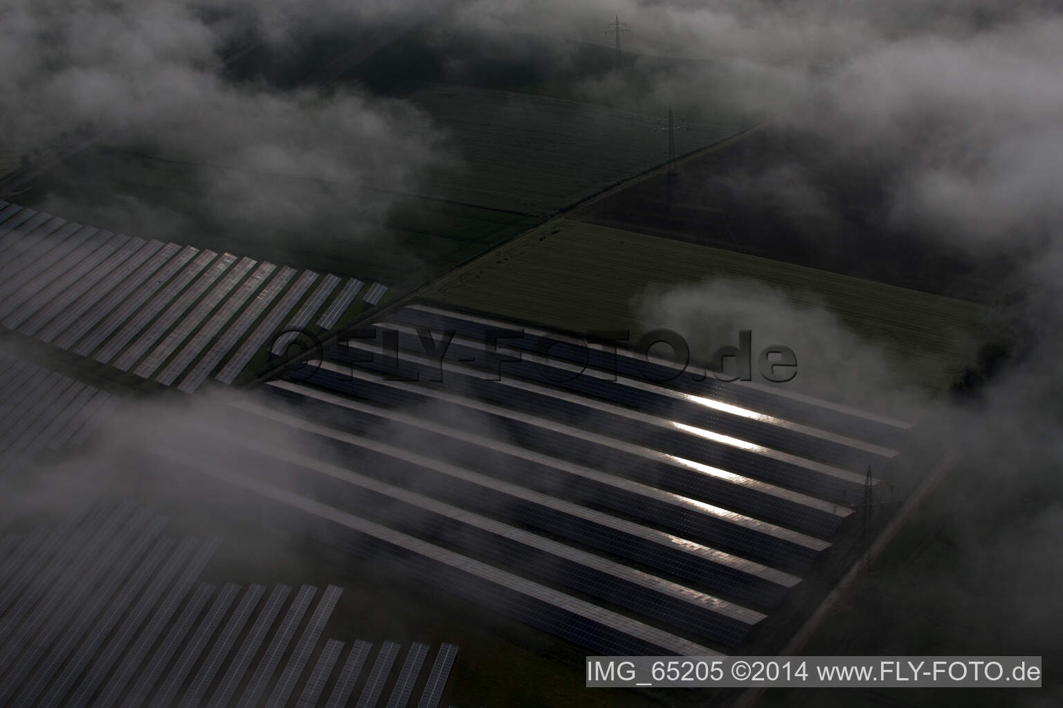 Weather-related panel rows of the photovoltaic plant of the solar park or solar power plant in the district Bredenborn in Marienmuenster in the state North Rhine-Westphalia from above