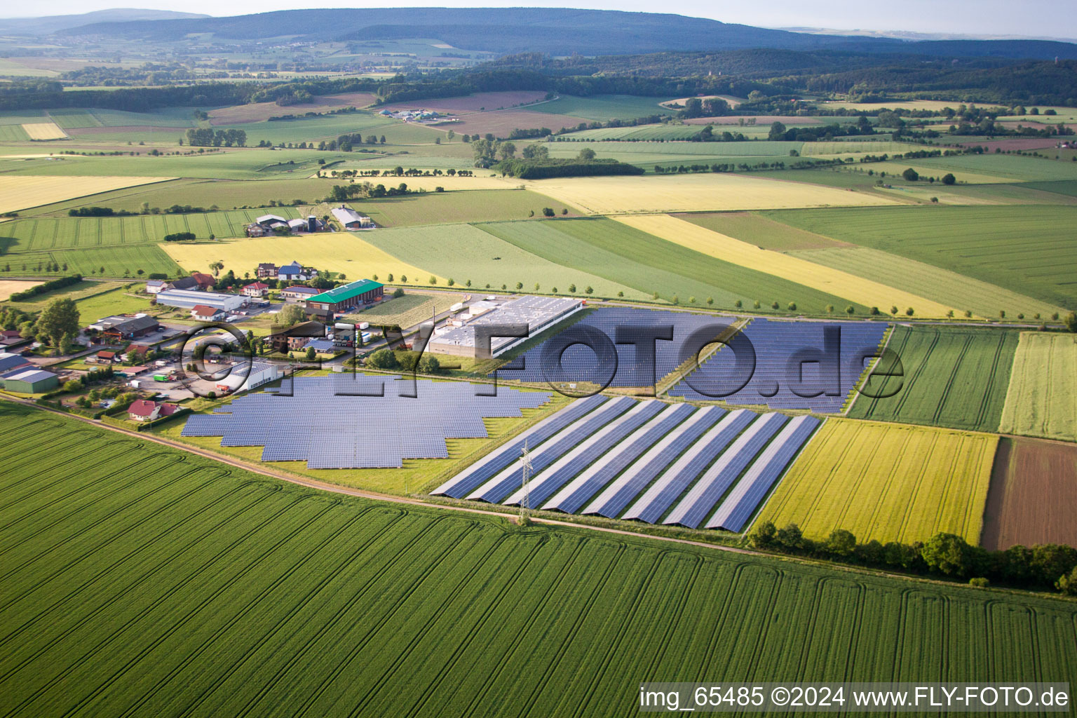 Aerial view of Panel rows of photovoltaic and solar farm or solar power plant in the district Bredenborn in Marienmuenster in the state North Rhine-Westphalia