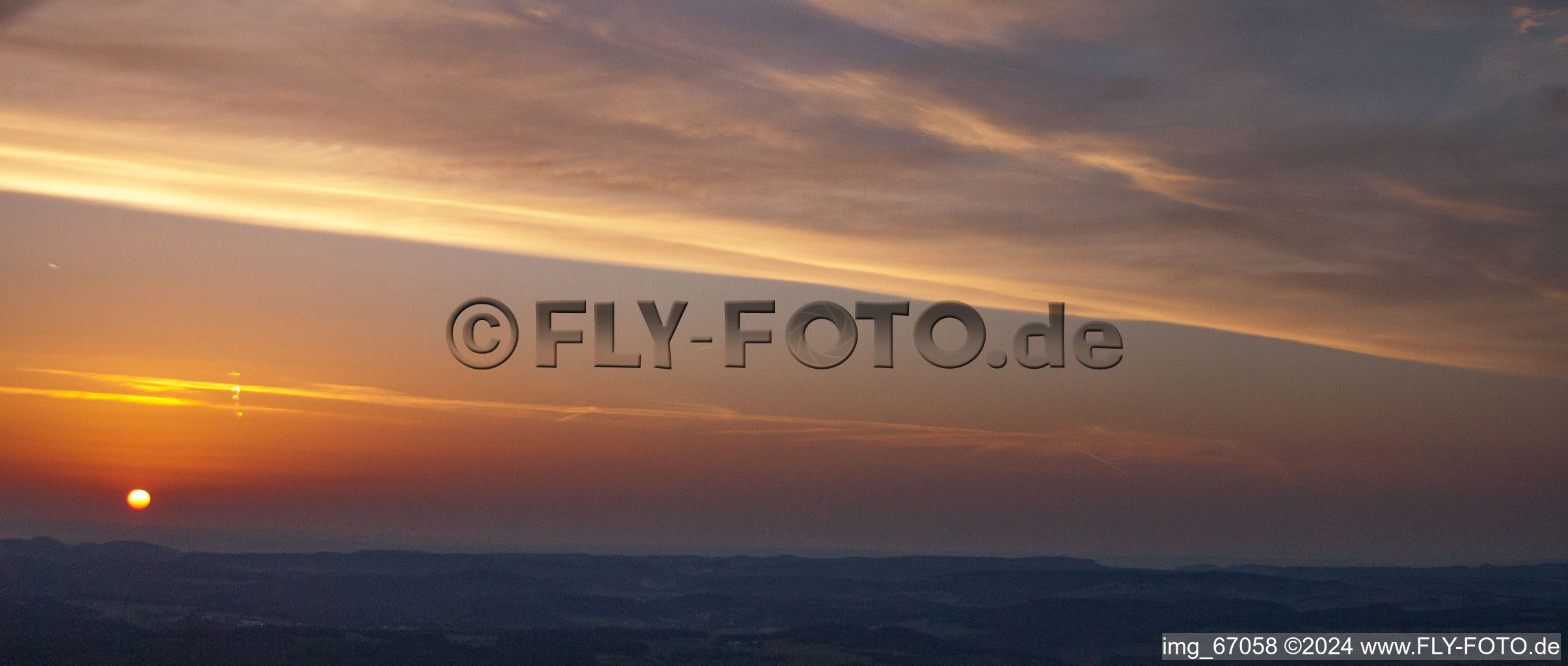 Sunset over the countryside in Ehingen (Donau) in the state Baden-Wurttemberg dyes the sky in a red and orange colour