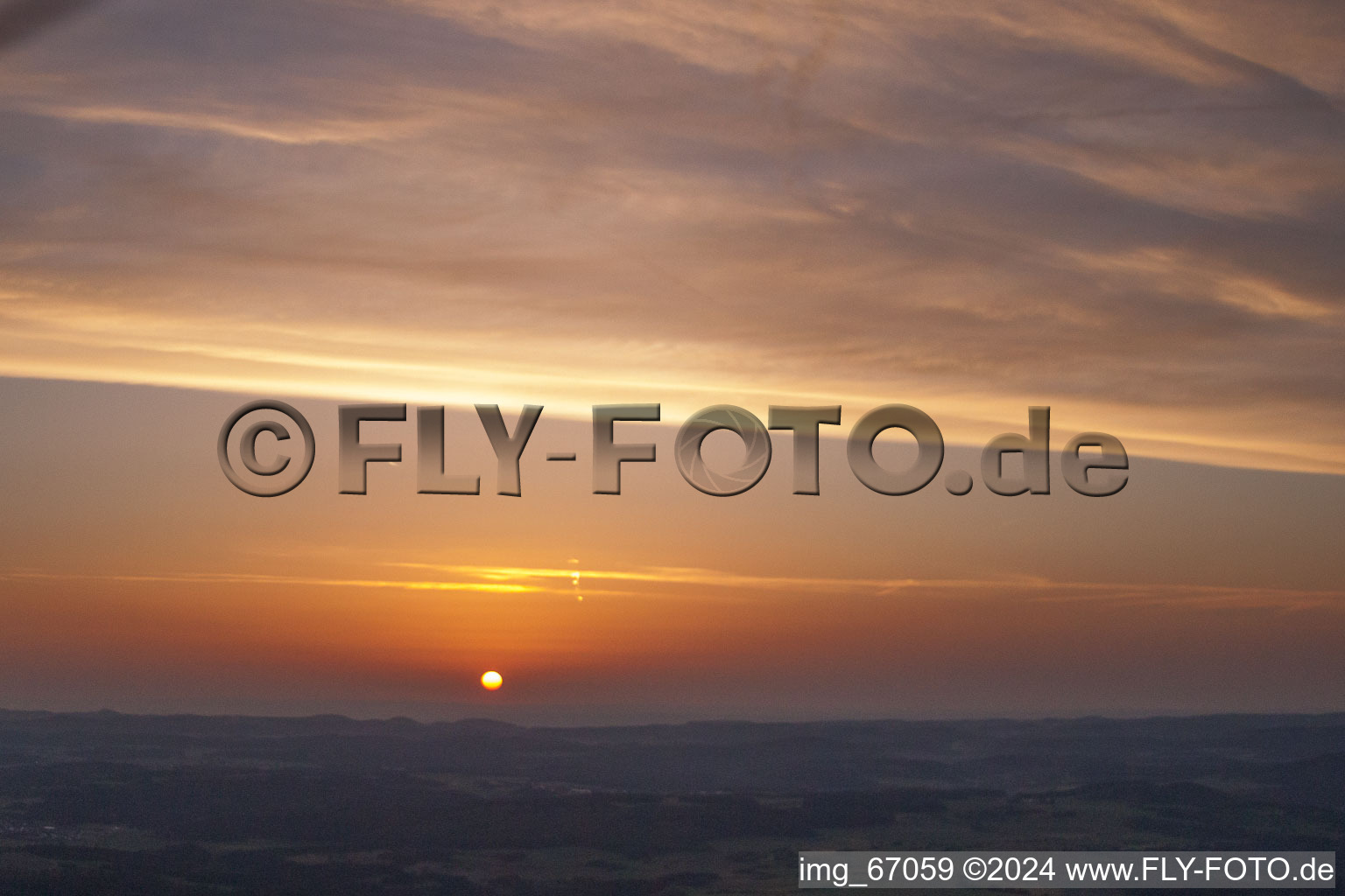 Aerial view of Sunset over the countryside in Ehingen (Donau) in the state Baden-Wurttemberg dyes the sky in a red and orange colour