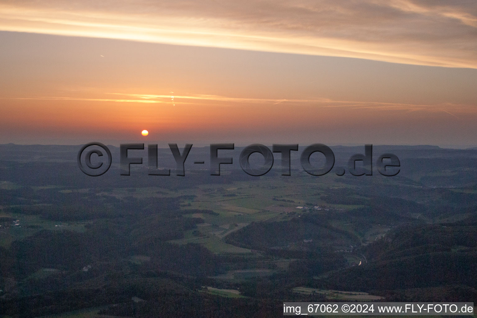 Sunset over the countryside in Ehingen (Donau) in the state Baden-Wurttemberg dyes the sky in a red and orange colour