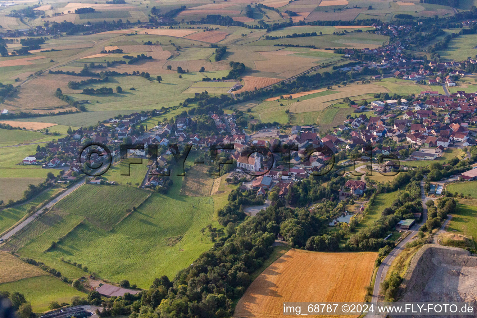 Village - view on the edge of agricultural fields and farmland in Oberleichtersbach in the state Bavaria, Germany