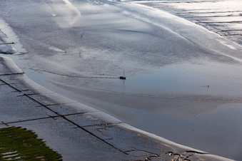Fishing boat returning home in the evening along the river mouth of Eider into the North Sea in Karolinenkoog in the state Schleswig-Holstein, Germany