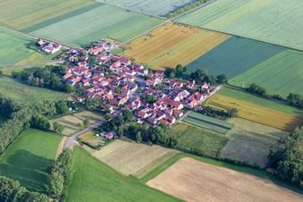 Agricultural land and field boundaries surround the settlement area of the village in Hausen in the state Thuringia, Germany