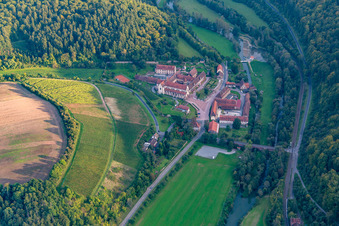 Aerial view of Complex of buildings of the monastery Bronnbach with garden and Church Mariae Himmelfahrt in Wertheim in the state Baden-Wurttemberg, Germany