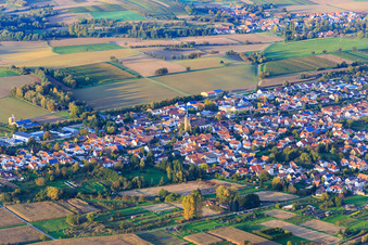 Village view between autumnal fields and meadows with parish church of St. Ulrich from the southwest in Kapsweyer in the state Rhineland-Palatinate, Germany