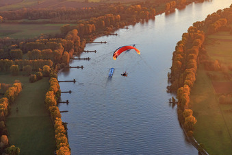 NATO ramp Gernsheim with paraglider over cargo ship on the Rhine at sunset in Gernsheim in the state Hesse, Germany