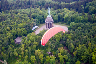 Tourist attraction of the historic monument Hermannsdenkmal with paragliders in Detmold in the state North Rhine-Westphalia