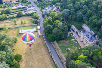 Aerial view of Hot air balloon start on Chateau de Perreux flying over the airspace in Nazelles-Negron in Centre-Val de Loire, France
