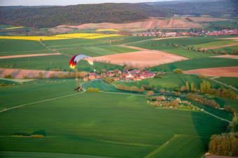 Aerial photograpy of Paraglider over the town in the district Wiebelsberg in Oberschwarzach in the state Bavaria, Germany