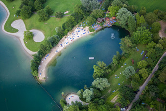 Bathers on the lawn and in the the pool of the nautral lake of the MIRAMAR Erlebnisbad in Weinheim in the state Baden-Wurttemberg