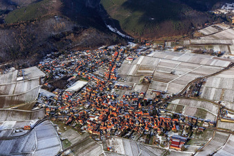 View of a winegrowing village on the edge of the Haardt in winter between snow-covered vineyards from the south in Frankweiler in the state Rhineland-Palatinate, Germany