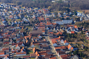 Speyerer Straße from the east with the Catholic Church of St. John the Baptist and Eugen Hufnagel GmbH & Co. KG in Harthausen in the state Rhineland-Palatinate, Germany