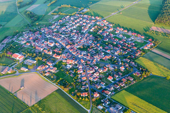 Aerial view of Village - view on the edge of agricultural fields and farmland in Wasserlosen in the state Bavaria, Germany