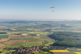 Aerial view of Paraglider over the village in the district Altenmünster in Stadtlauringen in the state Bavaria, Germany