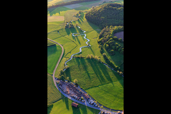 Aerial view of Meandering, serpentine curve of a stream - river Baunach in the district Frickendorf in Ebern in the state Bavaria, Germany