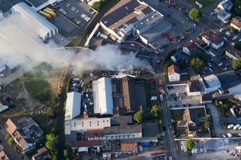Oblique view of Smoke and flames during the fire fighting to fire of a storage all for antiqities in the Werkstrasse in Speyer in the state Rhineland-Palatinate, Germany