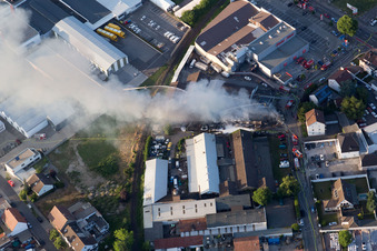 Smoke and flames during the fire fighting to fire of a storage all for antiqities in the Werkstrasse in Speyer in the state Rhineland-Palatinate, Germany from above