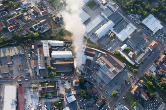 Smoke and flames during the fire fighting to fire of a storage all for antiqities in the Werkstrasse in Speyer in the state Rhineland-Palatinate, Germany from the plane