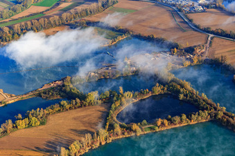 Dredging lakes for gravel extraction by Wolf gravel works under clouds in Leimersheim in the state Rhineland-Palatinate, Germany