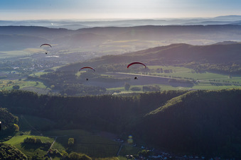 Forest and mountain scenery with 3 Paragleitern in Weserbergland in Holenberg in the state Lower Saxony, Germany