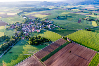 Agricultural land and field borders surround the settlement area of the village in Dingolshausen in the state Bavaria, Germany