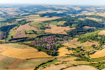 Aerial view of Agricultural land and field borders surround the settlement area of the village in Niedermoschel in the state Rhineland-Palatinate, Germany