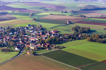 Aerial photograpy of Agricultural land and field borders surround the settlement area of the village in Bischwind in the state Bavaria, Germany