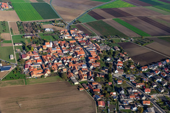 Aerial photograpy of Agricultural land and field borders surround the settlement area of the village in Kolitzheim in the state Bavaria, Germany