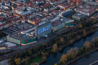 Aerial view of Building of the shopping center Stadtgalerie Schweinfurt and illumated SKF Hochhaus at dawn in Schweinfurt in the state Bavaria, Germany