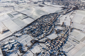 Wintry snowy village - view on the edge of agricultural fields and farmland in Niederhorbach in the state Rhineland-Palatinate, Germany