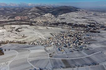 Wintry snowy wine yards surround the settlement area of the village in Birkweiler in the state Rhineland-Palatinate, Germany