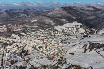 Wintry snowy location view of the streets and houses of residential areas in the Queich valley landscape surrounded by mountains in Albersweiler in the state Rhineland-Palatinate, Germany