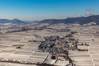 Aerial view of Wintry snowy village - view on the edge of agricultural fields and farmland in Roschbach in the state Rhineland-Palatinate, Germany