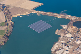 Floating solar power plant and panels of photovoltaic systems on the surface of the water on a quarry pond for gravel extraction in Leimersheim in the state Rhineland-Palatinate, Germany
