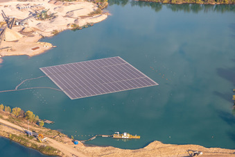 Aerial photograpy of Floating solar power plant and panels of photovoltaic systems on the surface of the water on a quarry pond for gravel extraction in Leimersheim in the state Rhineland-Palatinate, Germany