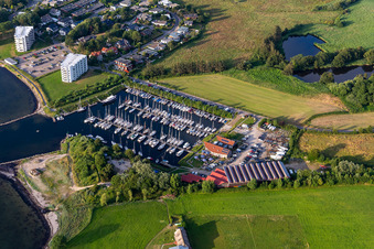 Aerial view of Pleasure boat marina of CLUB NAUTIC e.V. with docks and moorings on the shore area of the Foerde with Restaurant "Leuchtturm" in Schausende in Gluecksburg in the state Schleswig-Holstein, Germany