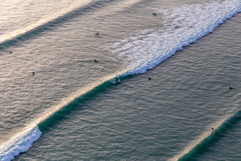 Aerial photograpy of Wave surfers in front of the Plage de Tronoën in Saint-Jean-Trolimon in the state Finistere, France