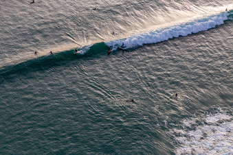Oblique view of Wave surfers in front of the Plage de Tronoën in Saint-Jean-Trolimon in the state Finistere, France
